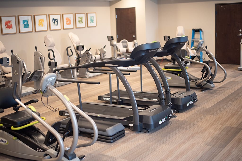 Two treadmills around other various exercise equipment in community fitness room.