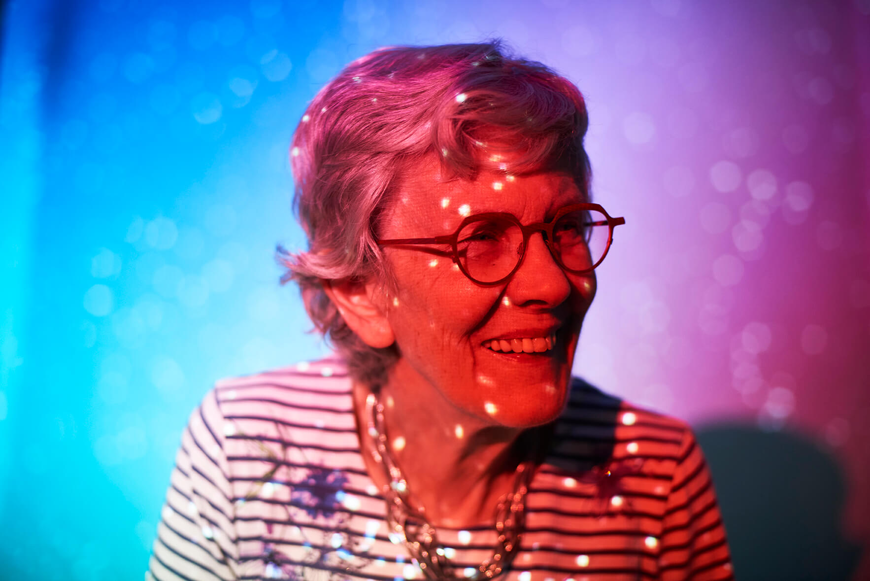 havenwood-burnsville-senior-in-projector Senior resident of Havenwood of Burnsville in projector light smiling